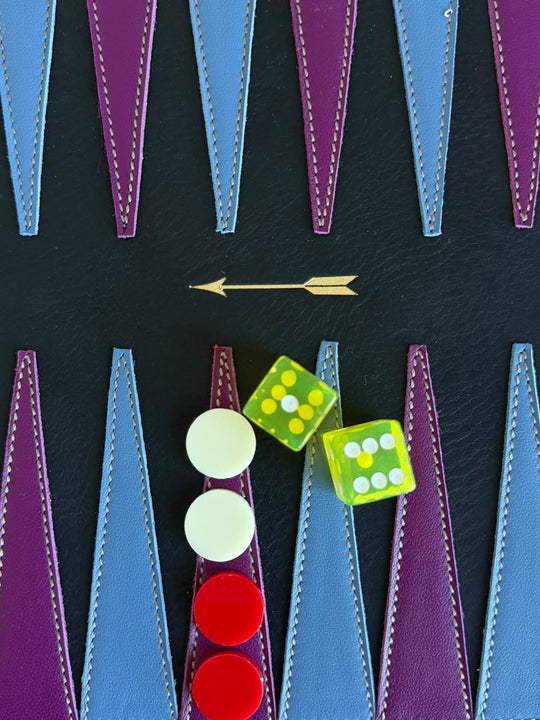 Backgammon de piel negra de Mercules con triángulos azules y morados, fichas y dados en juego